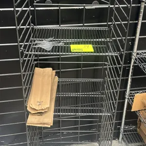 Metal wire merchandising rack. Features a gray metal frame with adjustable wire shelves. Designed for retail product display. Contents not included.