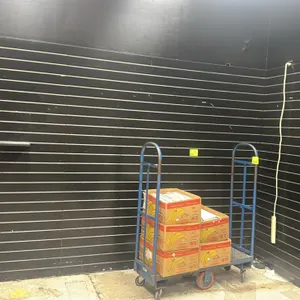 Slatwall paneling and shelving lot. Features black finish slatwall panels with integrated horizontal grooves. Includes black laminate shelves on mount