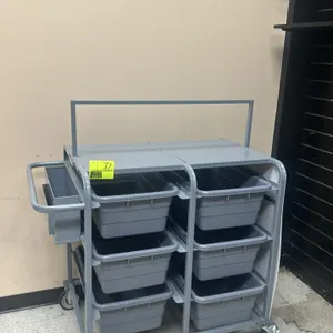 Metal stock picker cart. Features a steel frame, a side-mounted utility pocket, and includes six removable gray poly totes. 36"L. Mounted on casters.