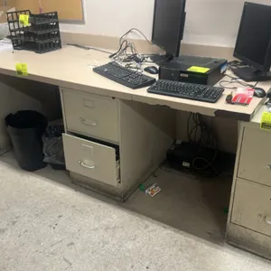 Metal 2-drawer vertical filing cabinet. Features a beige finish, pull handles, and integrated label holders. Note: Desk, computers, office supplies, a