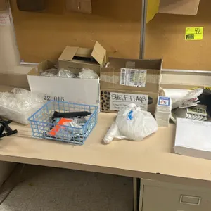 Assorted office and retail merchandising supplies. Includes a 4-tier black plastic document tray, shelf flags, swing tags, plastic merchandising hooks