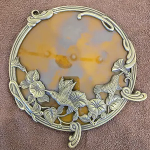28 - 9" round hummingbird picture frame/mirror with floral design.  Metal frame appears to be brass.