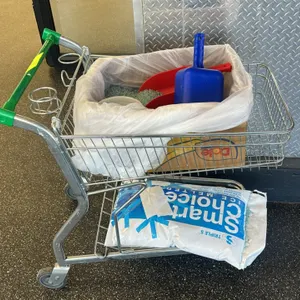 Metal wire shopping cart package. Includes a wire shopping cart with a green handle, a partially filled 50 lb bag of Triple S Smart Choice ice melter,