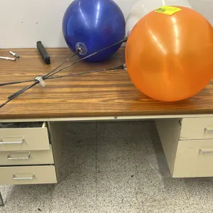 Double-pedestal office desk. Features a wood-grain laminate top and a beige metal base with chrome legs. Equipped with five drawers, including three o