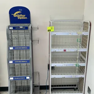 Two metal wire portable merchandisers. Includes (1) 'The Weather Station' tiered umbrella display rack with blue header sign and side-mounted wire hol