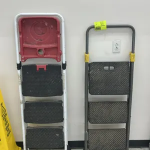 Two Cosco folding metal 3-step ladders. Includes one white frame ladder with a red top utility tray and black textured steps, and one gray frame ladde