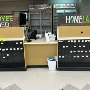 12'x3' laminate service counter. Features modular construction with a cream laminate countertop, two front-facing black pegboard merchandise displays 