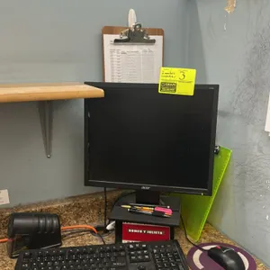Acer computer monitor. Package includes a wired keyboard and a Lenovo wired mouse. Mounted on a desktop stand. Background items, sharpener, paperwork,