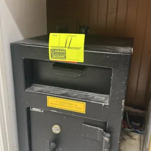 AMSEC drop safe. Features a front-loading depository hopper and a lower compartment with dual key locks. Finished in black textured paint. 12"x12"x24"