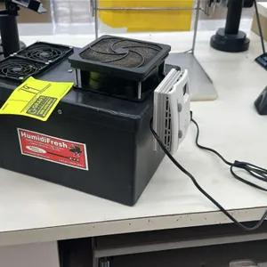 HumidiFresh humidor and cigar locker humidity maintainer. Features a black plastic reservoir tank, integrated dual circulation fans, a single larger f