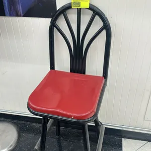 High-top dining chair. Features an arched metal backrest with fan-style vertical slats, a contoured red seat, and a black tubular metal frame. Mounted