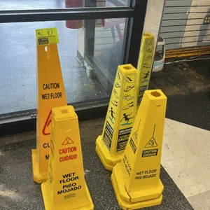 Assorted poly wet floor signs. Lot includes a variety of yellow plastic safety cones of various heights and designs, including Rubbermaid Commercial P