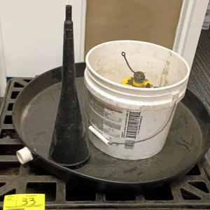 Water heater catch pan and basin utility lot. Includes a circular plastic catch pan with drain fitting, a black plastic grid basin base, a Wayne Water