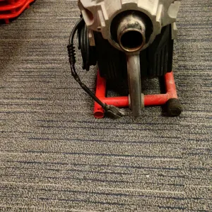 RIDGID K-60SP compact sectional drain cleaning machine. Features a forward/off/reverse toggle switch, clutch handle, and red metal carrier frame. S/N: