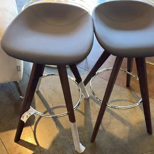 PAIR OF CALLIGARIS BACKLESS CONTOURED SEAT STOOLS. SLATE COLOR LEATHER AND WOOD LEGS.