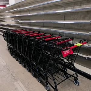 Metal shopping cart. Features a black wire basket and frame, a red plastic handle sleeve, a fold-out child seat with a red plastic flap, and grey fron