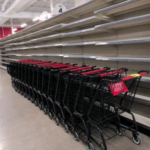Metal shopping cart. Features a black powder-coated wire basket and frame, a red plastic handle with "Grocery Outlet" branding, a red plastic child se