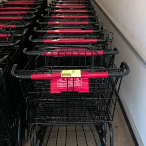 Metal shopping cart. Features black wire basket and frame, red plastic handle grip, folding child seat, and lower wire storage rack. Mounted on caster