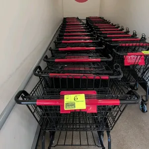 Metal shopping cart. Features black wire basket and frame construction, red plastic handle, integrated red plastic child seat, and gray front corner b