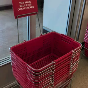 Stack of red poly shopping baskets with dual metal handles, branded 'Grocery Outlet Bargain Market'. Includes a gray metal stand with integrated sign 