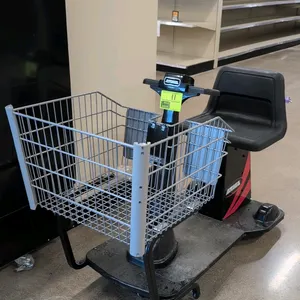 Amigo electric mart cart motorized shopping trolley. Features a front wire basket, molded black seat, and handlebar tiller controls. Equipped with an 