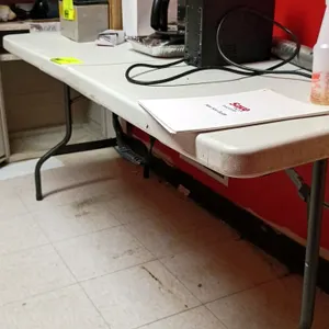 Unbranded 6' poly folding table. Features a white molded plastic tabletop, folding metal legs, and an integrated carrying handle. Dimensions: 6'L. Con