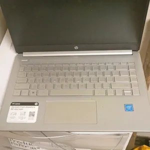 HP laptop. Features a silver-tone finish, integrated keyboard, trackpad, and built-in display. Features an Intel processor. Storage drawers in backgro