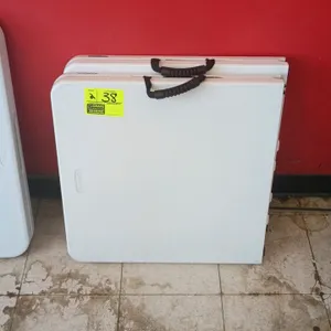 Lifetime 4' poly folding table. Features a white polyethylene fold-in-half design with a built-in carrying handle and folding metal legs. 4'L.