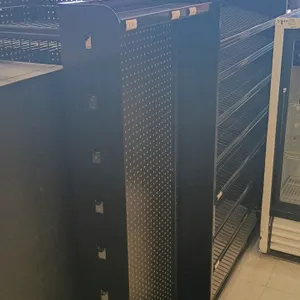 Double-sided checkout lane merchandiser display. Features black metal construction, pegboard end panels, and adjustable wire shelving. Dimensions: 76"