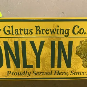 A New Glarus Brewing Co. Metal Advertising Sign. (New Glarus Brewing Co., circa 1999) An embossed metal advertising sign for the New Glarus Brewing Co