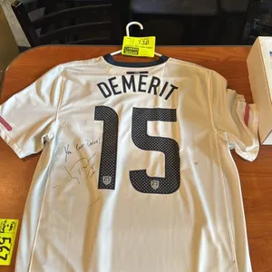 An Autographed Jay DeMerit Team USA Jersey. (Nike, 2010) A white Nike Dri-Fit jersey featuring 'DeMerit' and number 15 on the back. Autographed by Jay