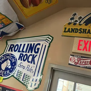A Collection of Brewery Metal Signs. (Various, circa 2000s) A trio of beer advertising signs. Includes a contoured Rolling Rock Extra Pale sign with h