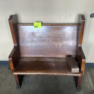 Wooden church pew. Features solid wood construction with decorative trefoil cutouts on the side panels. Includes a metal bracket mounted on the seat. 