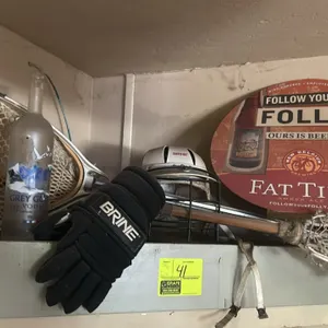 A Collection of Vintage Lacrosse Gear and Bar Memorabilia. (Various Makers, Late 20th Century) Includes a Brine helmet, Brine glove, wooden-shaft lacr