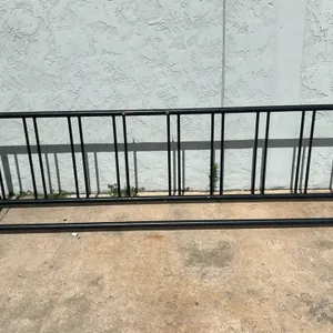 Metal bicycle rack. Features black powder-coated tubular steel construction with vertical stall dividers. Freestanding design. 9'L.