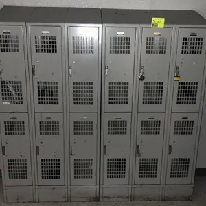 Metal 2-compartment employee lockers. Features a double-tier design with ventilated doors, padlock latches, and a gray finish. Configured as two banks