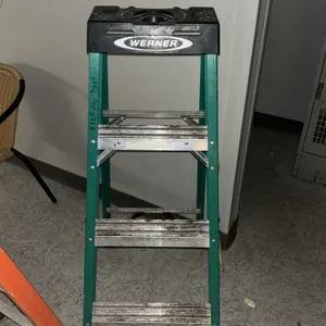 Werner 4' fiberglass stepladder. Features green fiberglass rails with aluminum steps and a black molded plastic top cap with tool slots. 4'H. Note: Ba