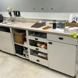 Laminate counter with under-counter cabinets and drawers. Features a light-colored laminate countertop and modular storage bases including drawers, op