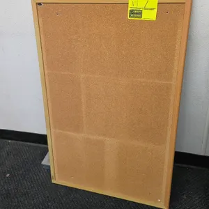2018 DEL 43793 corkboard. Features a natural cork bulletin surface and a light wood frame. Includes corner mounting brackets on the reverse side for h