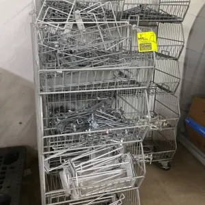 Lot of 14 stackable wire merchandiser baskets. Features open-front design for easy access. Includes a large assortment of metal pegboard hooks. Bottom