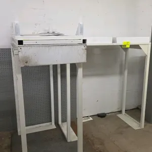 Metal merchandise display stand. Features a white-painted metal frame with two top trays. 46.5" x 21" x 49". Background items not included.