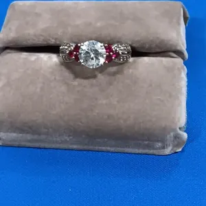 Silver Tone Round Cut Flanked By Red Stones.