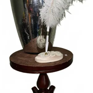 Round Wood Pedestal Table with Glass Vase, Feather Pen, and Base
