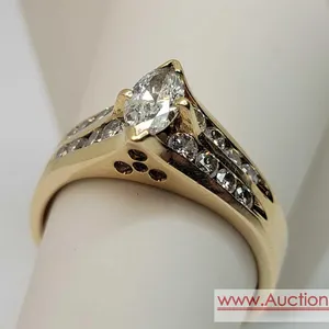 A Beautiful Marquise Diamond surrounded by 16 Round Diamonds in a size 7.75, 14k Gold band. The Marquise measures  approximately 7.72 mm x 3.73 mm sur