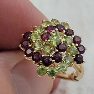 Beautiful Cocktail ring featuring 14 Peridot and 14 Amethyst faceted stones each measuring 3.5 mm. Yellow Gold band is marked 14k and Korea. Bridge ma