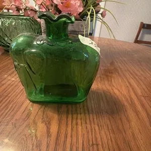 This is a vintage 1970s green glass bottle vase