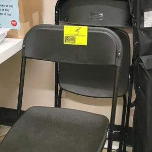 Poly folding chair featuring a black molded plastic seat and backrest. Supported by a black-finished metal folding frame.
