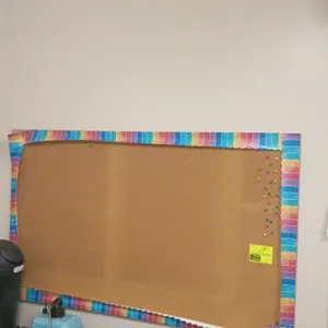 Cork bulletin board. Features a cork tack surface with a decorative paper border. 60"W x 36"H. Wall-mounted. Background items not included.