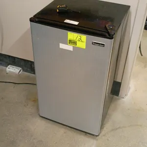 Magic Chef compact refrigerator. Features a silver-tone front door with a black cabinet, glass shelves, integrated door storage, and a bottom crisper 