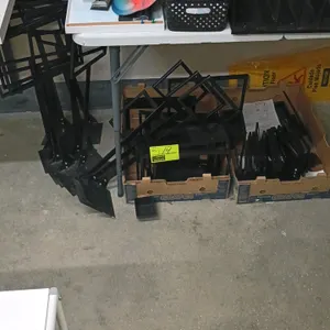 Quantity of assorted retail sign holders. Includes black metal sign frames and stemmed sign holders with flat metal bases. Features various sizes desi